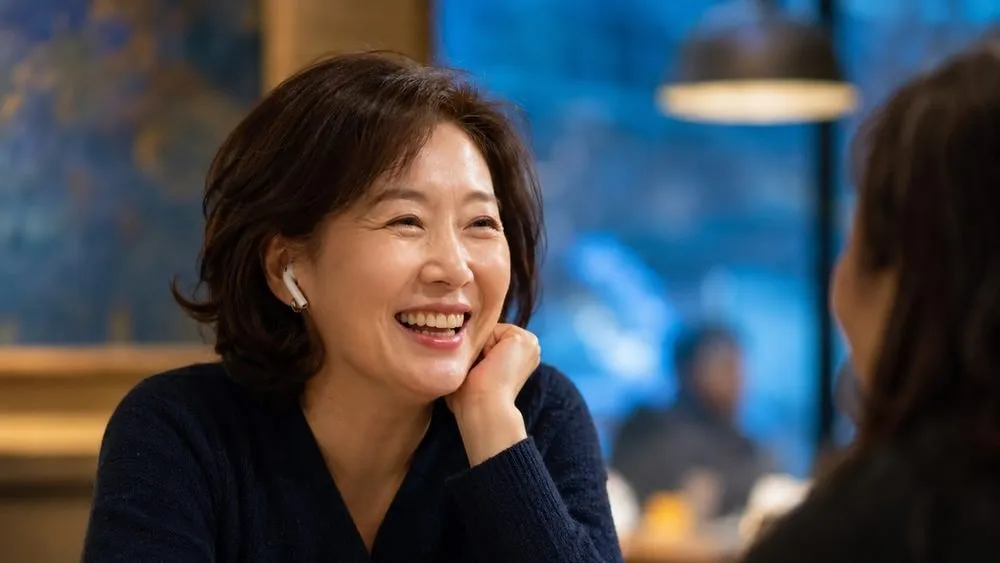 시끄러운 카페에서 이어폰을 끼고 마주 앉은 상대와 대화하는 모습